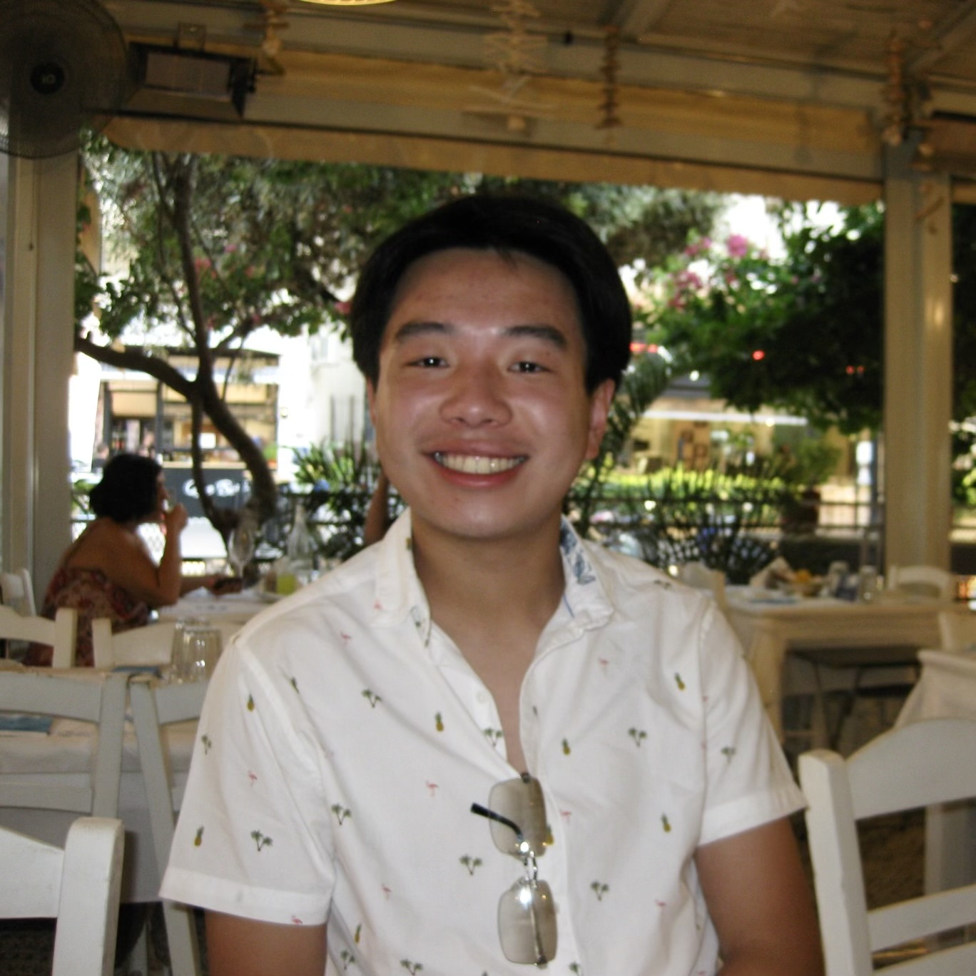Ryan Chan in a hawaiian shirt smiling at dinner